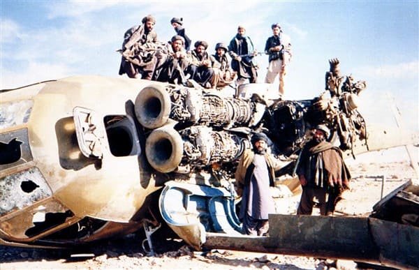 Afghan mujahideen standing on wreckage of a shot down Afghan government helicopter in Zabul province 1990