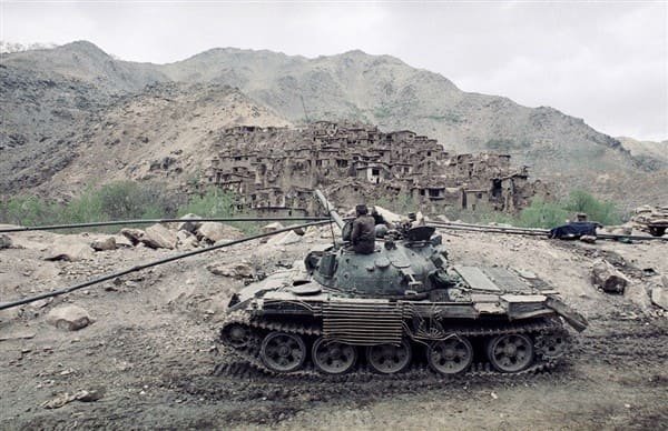 Soviet T-62 tank in Afghanistan near a mountain village during the 1980s war