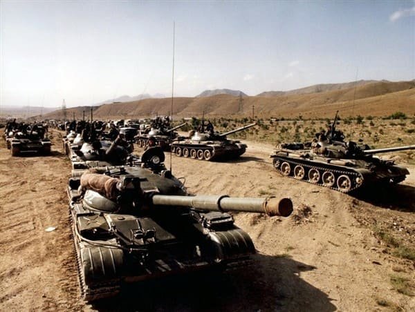 Soviet tanks moving along a road in Afghanistan during the 1980s war