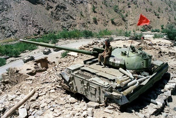 Soviet T-62 tank on high ground in Afghanistan early 1980s covering fuel convoy during Afghan War