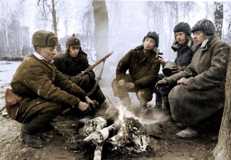 Red Army soldiers warming themselves by a fire during winter in World War II