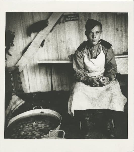 Soviet soldier peeling potatoes in field kitchen during World War II