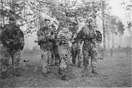 Soviet scouts wearing camouflage moving through forest WW2
