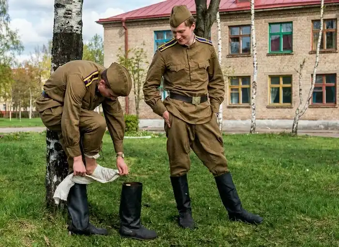 Cold War Soviet soldiers wrapping portyanki foot wraps before putting on kirza boots.