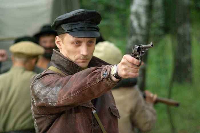 Film portrayal of a Chekist aiming a revolver in a leather jacket